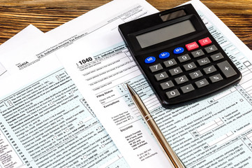 Tax form with calculator and pen on the table.
