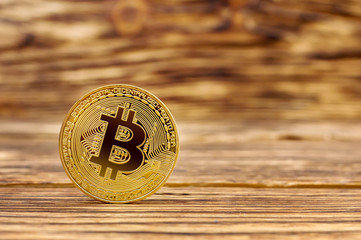 Metal bitcoin on wooden table. Close up. Business background.