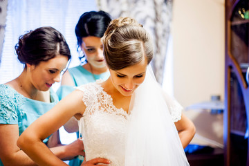 Bride's girlfriends help dress their clothes