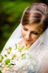 Dreamy bride holds green bouquet