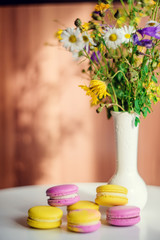 Morning cup of coffee, cake macaron, gift or present box and flower on light table from above. Beautiful breakfast. Flat lay style.