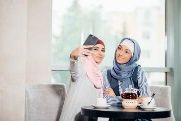 young beautiful muslim woman taking a self portrait with camera phone