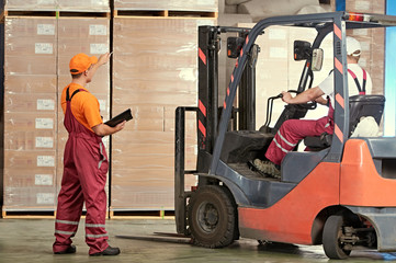 Warehousing and storage. warehouse workers works with forklift loader