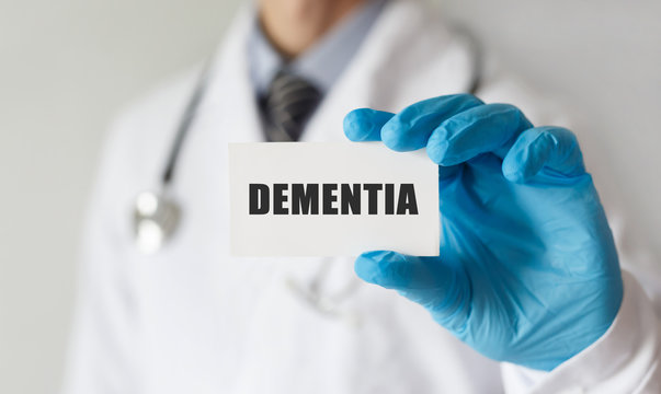 Doctor holding a card with text DEMENTIA, medical concept