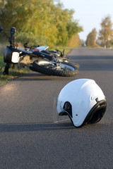 Photo of helmet and motorcycle on the road, the concept of road accidents