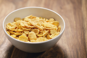 corn flakes in white bowl on table closeup