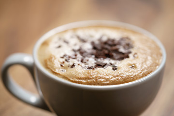 fresh cappuccino with chocolate flakes on wood table