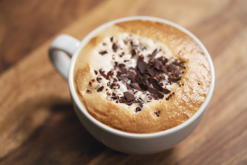 fresh cappuccino with chocolate flakes on wood table
