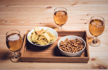 Three beer glasses and beer snacks on wooden table. Vintage style