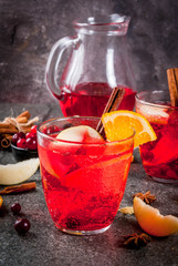 Fall and winter cold drinks, cranberry and orange holiday christmas punch with cinnamon, anise stars,  on black background copy space