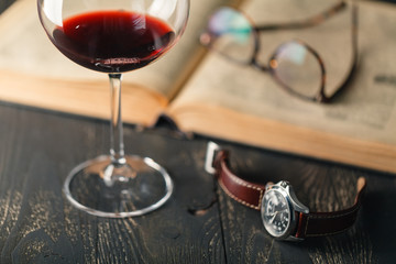 composition with glass of wine with old books on table close up
