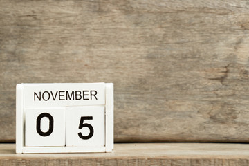 White block calendar present date 5 and month November on wood background