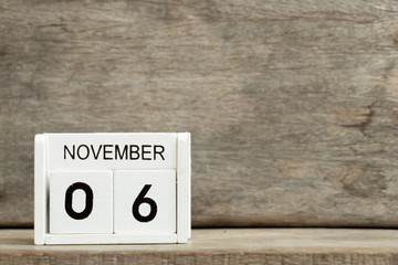 White block calendar present date 6 and month November on wood background