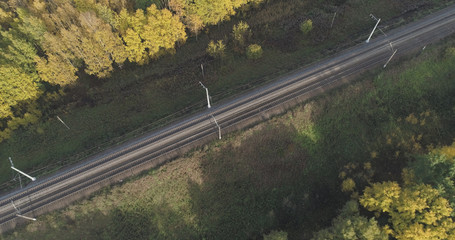 Aerial shot of railroad between autumn trees in forest in october