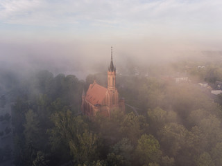 Early morning aerial view over city Druskininkai, Lithuania. City cover in summer fog clouds.