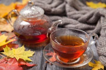 Autumn Still Life: Tea on maple leaves on a wooden table