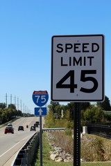 The road sign on the side of the highway on a close up view.