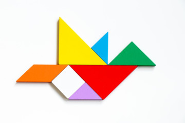 Colorful wood tangram puzzle in flying bird shape on white background