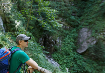 Photo of man with backpack on background rock