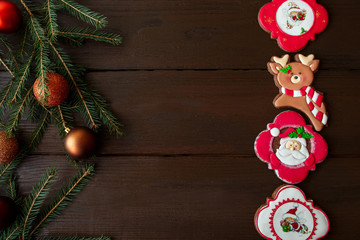 Christmas background, gingerbreads and fir with balls on wooden background.Christmas sweets.Copyspace for your text	