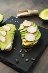 Healthy breakfast, avocado bread and radish served on a slate tray