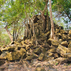 Fototapeta na wymiar Prasat Beng Mealea in Angkor Complex, Siem Reap, Cambodia. It is largely unrestored, old trees and brush growing near towers and many of its stones lying in great heaps. Ancient Khmer architecture.