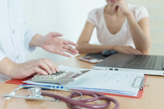Health care costs concept picture : Physician in medical practice with patients. Conversation and advice of the treatment and medical costs.