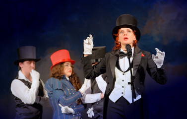  girl in tuxedo and hat singing on stage