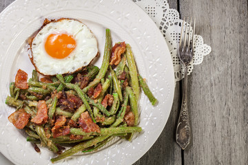 Healthy sauteed green beans with bacon and fried egg