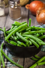 Raw green beans in a black dish