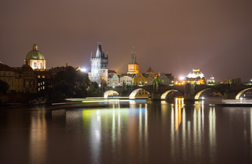 Fototapeta na wymiar Charles Bridge and the Mill peninsula in Prague. Czech Republic. Light trails from boats walking along the river