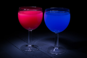 red and blue cocktail in a glass on a black background