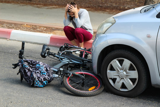 A Woman Holding Her Head Near A Traffic Accident Between Electric E Bike And Car