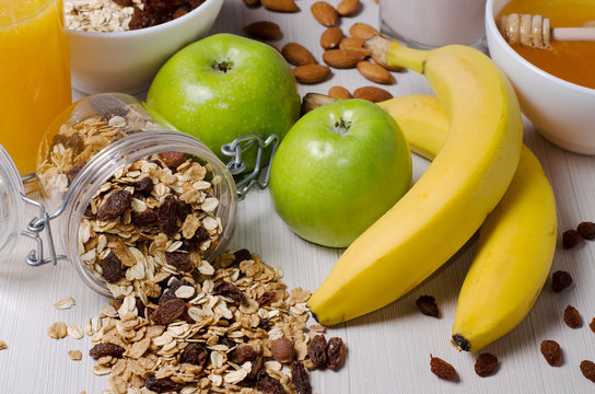 Healthy Breakfast. Granola, apples, bananas, nuts on a white table