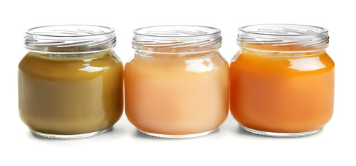 Jars with baby food on white background
