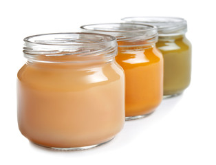 Jars with baby food on white background