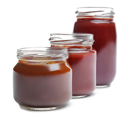 Jars with baby food on white background