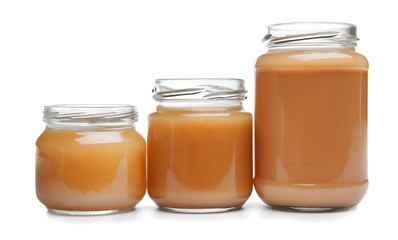Jars with baby food on white background