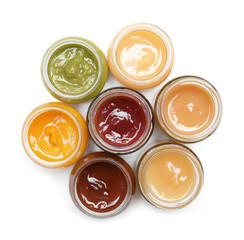 Jars with different baby food on white background
