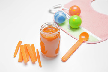 Composition with tasty baby food in jar on white background