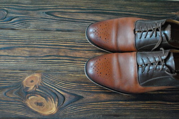 Męskie buty na drewnianym rustykalnym tle - obrazy, fototapety, plakaty