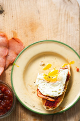 Bread slices with tomato relish, turkey rasher and fried egg 
