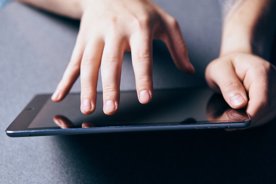 black tablet close-up, business, fingers touching the screen