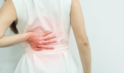 A woman in white dress feeling pain on his back. Office syndrome. Back pain from work. Herniated nucleus pulposus. spine pain. spinal degeneration.