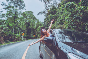 Asian women travel relax in the holiday. Traveling by car park. happily With nature, rural forest