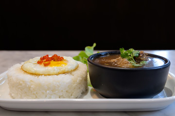 Fried egg on rice with boil soup.