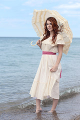 vintage woman with parasol at the seaside