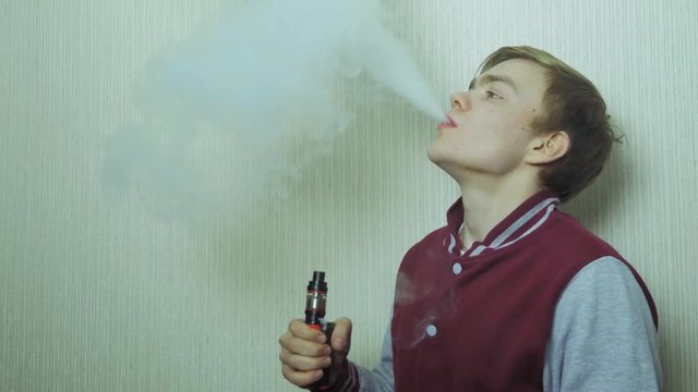 Young man smoking electronic cigarette. Young Man Using Vapourizer As Smoking Alternative