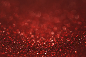 Dark red (ruby) glitter background. Sparkle texture. Abstract gradient background blurred for New...