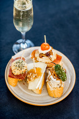 Beautiful and colorful set of pinchos, traditional spanish snack related to tapas, with glass of wine outdoors on the table
